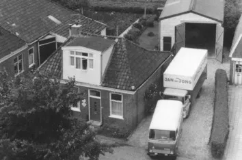 In 1970 maakte Jan de Jong deze ‘luchtopname’ vanaf het dak van de Eiberhof. Behalve het huis van zijn ouders, de loods en de auto’s toont de foto ook een deel van Zuidhorn dat grotendeels verdween.